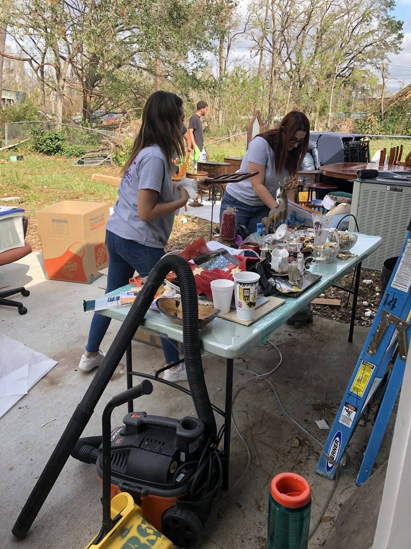 Magnolia team cleaning household contents at an outdoor work table