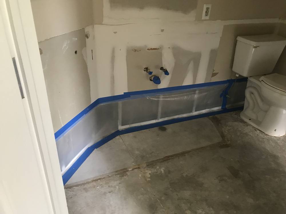Plastic containment taped along the walls of a room