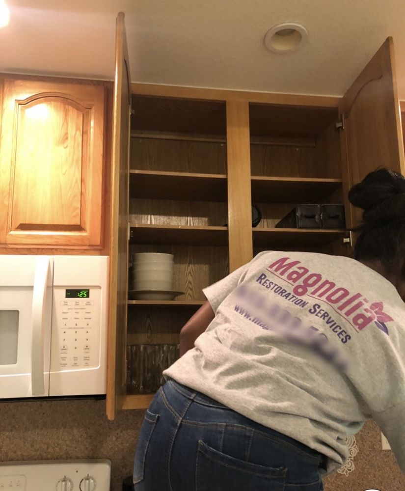 Magnolia technician emptying kitchen cabinets during a pack-out
