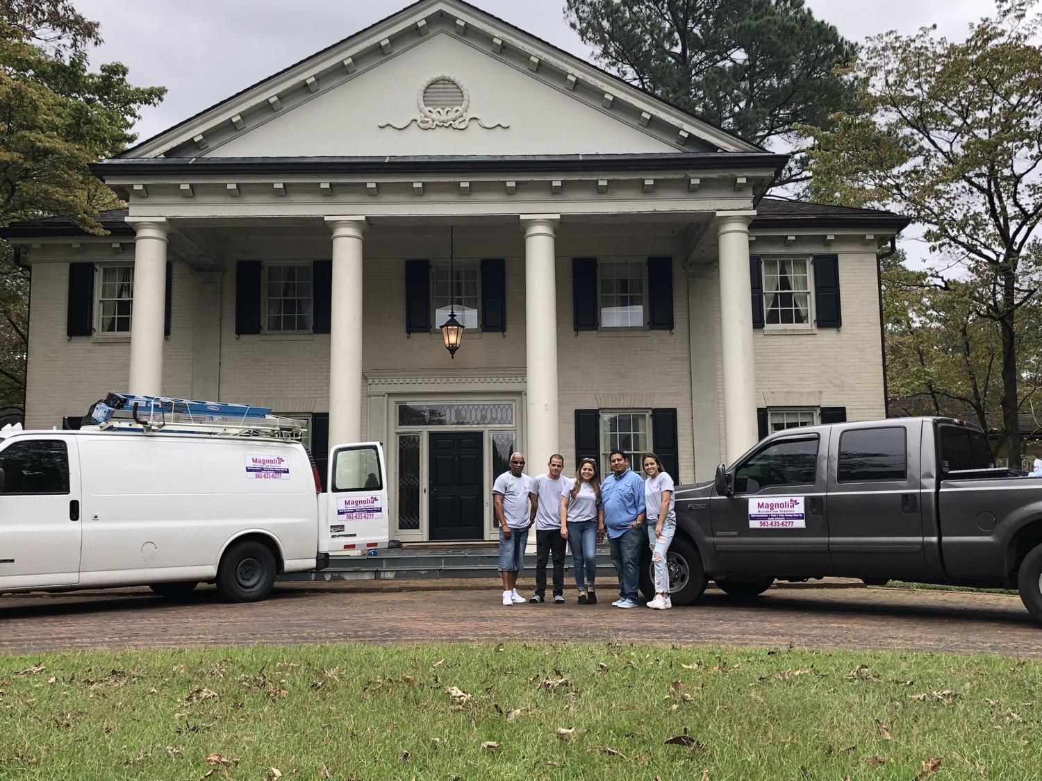 The Magnolia team with company vehicles on a job