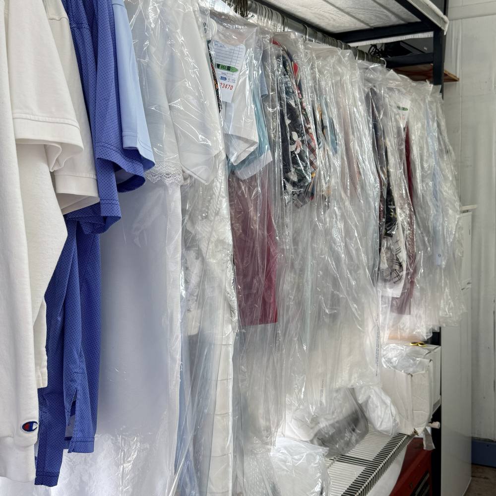 Cleaned garments in clear bags on a rack